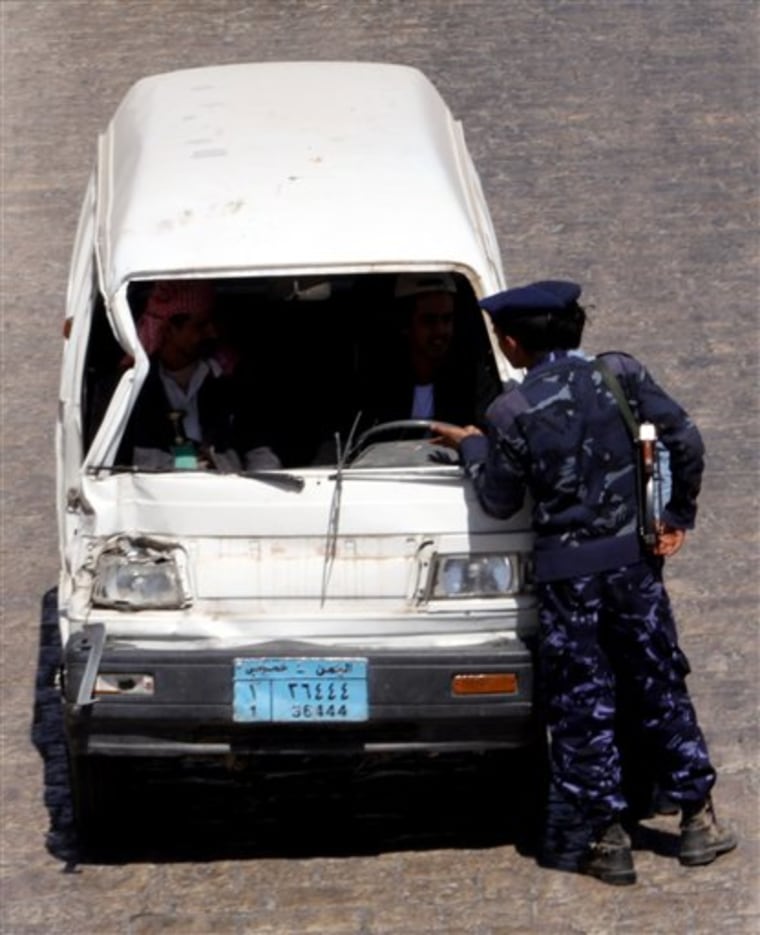 Yemeni policemen stop a car at a checkpoint Thursday at a street in the capital San'a.